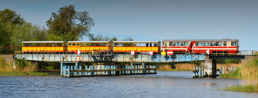 Pociąg ŻKD przejeżdża przez most obrotowy nad Szkarpawą.